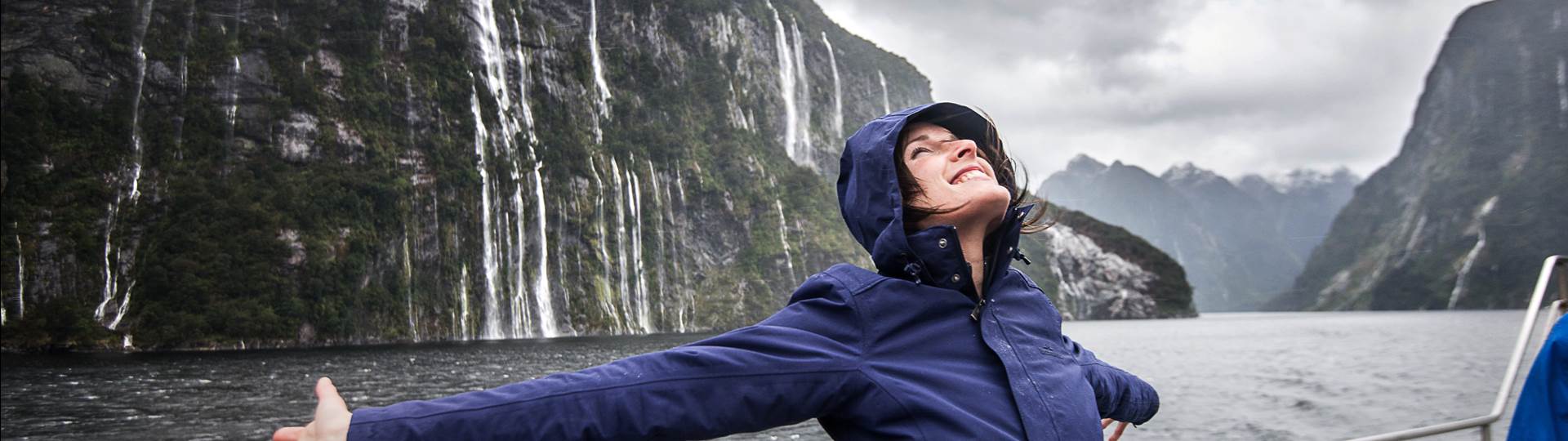 Woman enjoying the waterfalls in Fiordland National Park